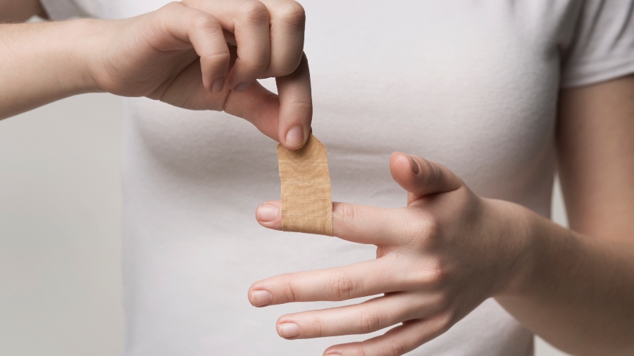 woman putting bandaid on finger