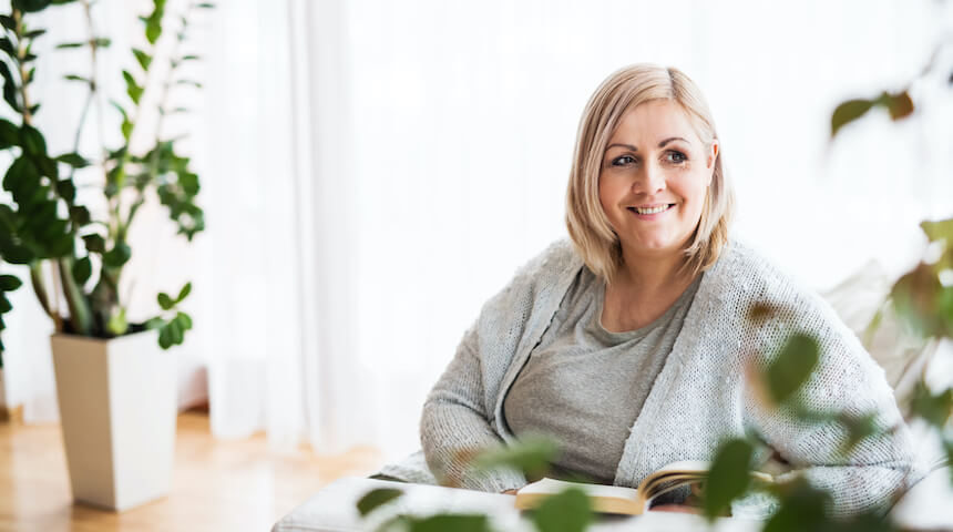 Woman smiling and reading a book