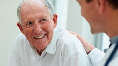 A patient talking to his doctor at his routine heart health checkup.