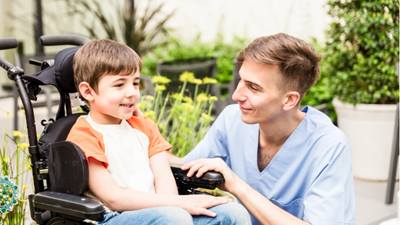 A young boy being entertained by a physicians assistant while waiting to see his doctor.