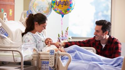 Mom and dad with new baby in hospital room