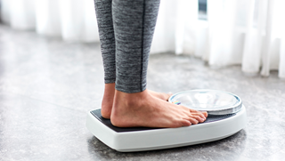 Woman weighing herself.