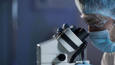 Researcher looking through microscope