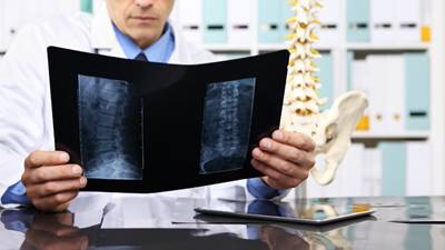 Spine surgeon looks at X-rays