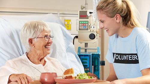 Volunteer bringing food to hospital patient