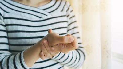 Woman holds wrist in pain