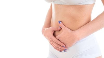 Women standing with hands on stomach