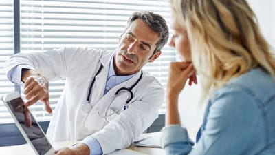 doctor explaining results to woman on ipad
