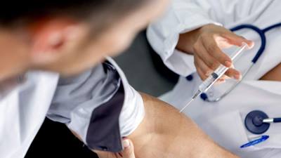 doctor injecting flu vaccine into patients arm