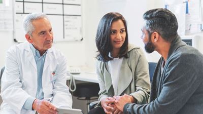 Doctor speaking with young couple