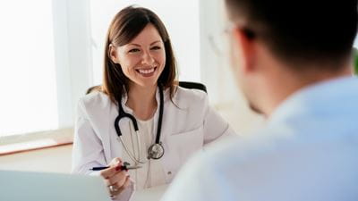 Female doctor speaking with male patient