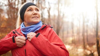 Female runner zipping up jacket in cold weather