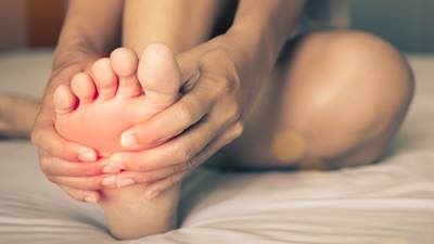 Woman holding foot in pain