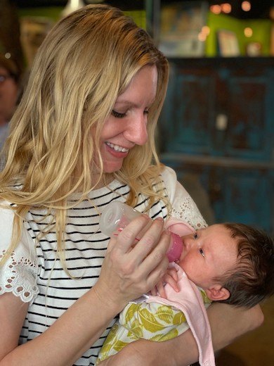 Martine Holden holding and feeding baby