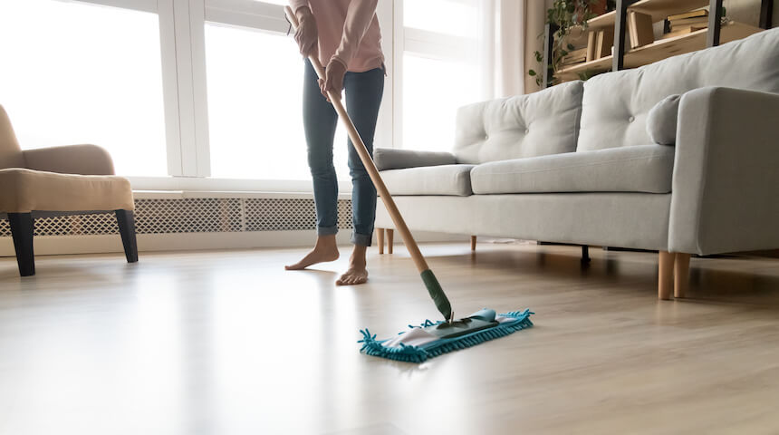Woman sweeping floor of a clean home