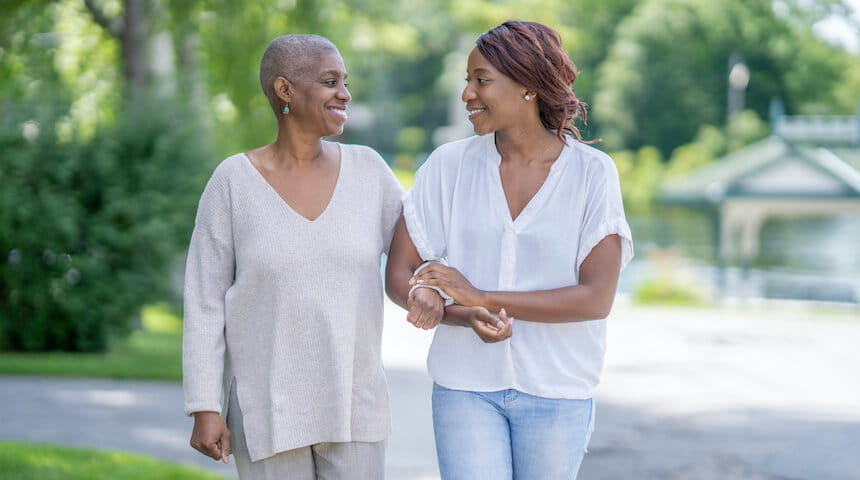 Two women walking outside with arms linked