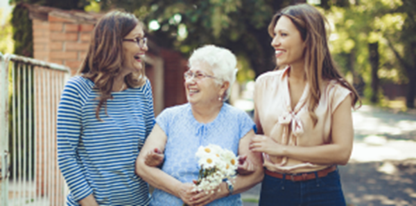 Three women walking and smiling together.