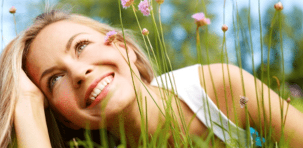 A woman day dreaming in the grass.