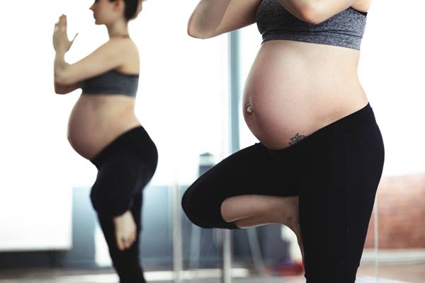 Pregnant woman practicing yoga.
