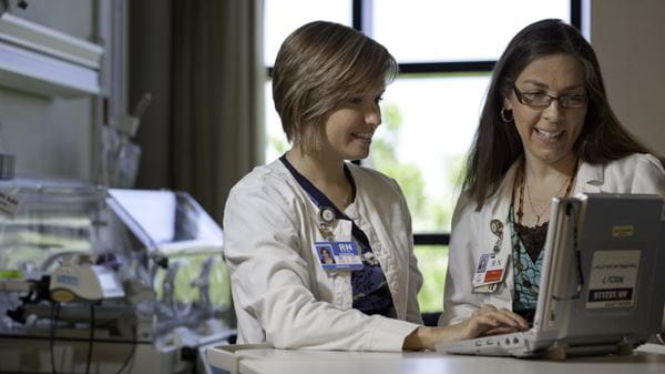 Orlando Health nurses working on a laptop.