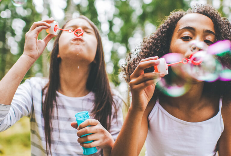 two girls blowing bubbles