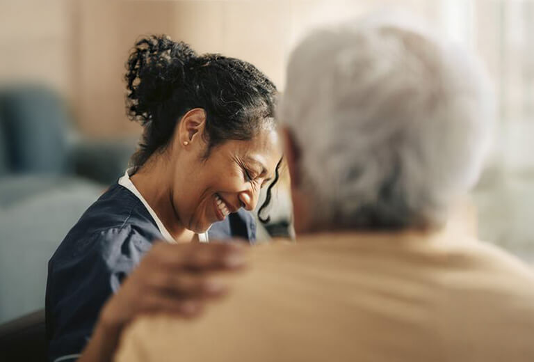 Doctor smiling with hand on patient shoulder