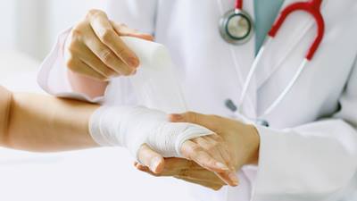 Doctor wrapping bandage around arm