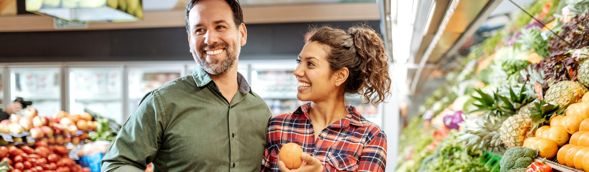 couple in grocery store shopping for produce