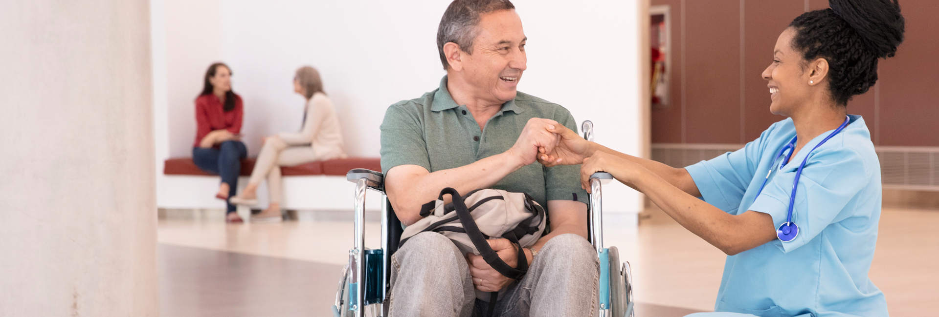 nurse shaking hands with man in wheelchair