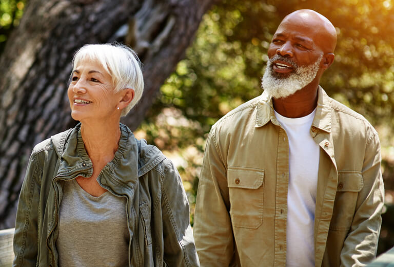 Couple with gray hair outside looking off camera
