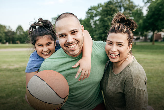 Man with wife and daughter playing basketball