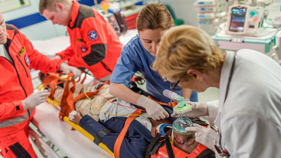 Doctors working on someone laying on stretcher