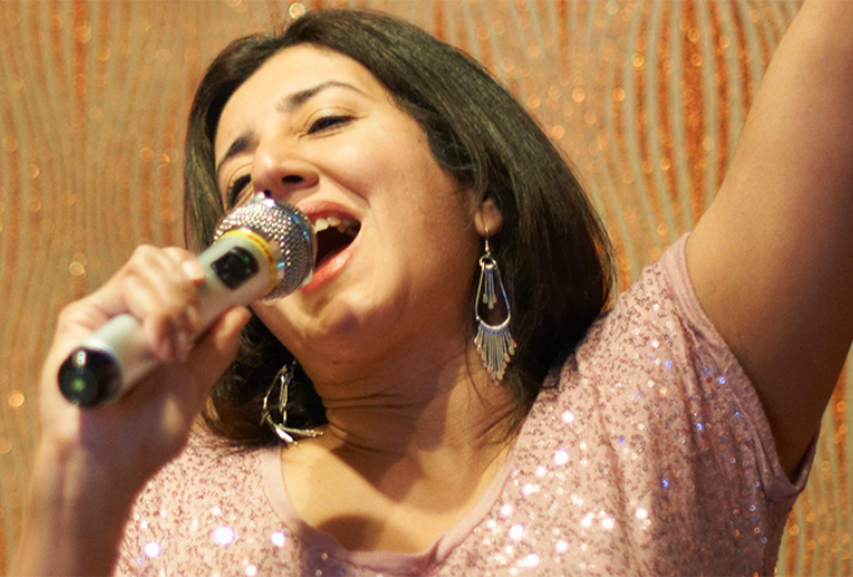 Lady singing in a spotlight