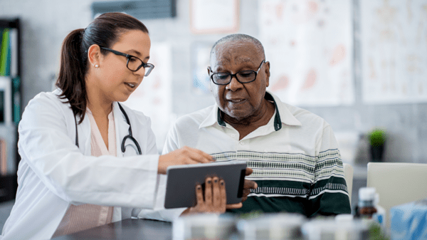 Female doctor speaking with elderly male patient