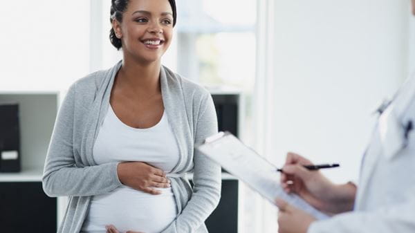 Pregnant woman speaks with doctor