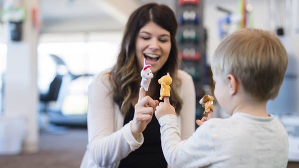 Therapist playing with boy in clinic