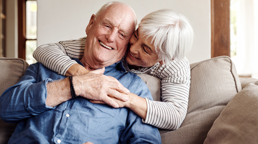 woman with arms wrapped around man on couch