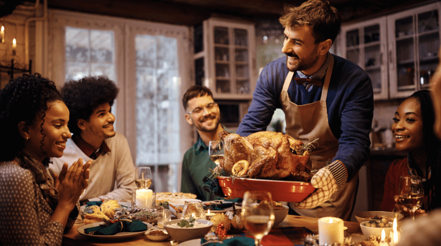 Guy serving friends a turkey for dinner