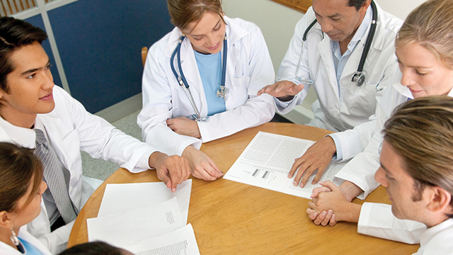 Doctors talking around conference table