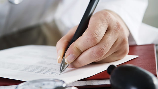 Doctor's hand writing on paper