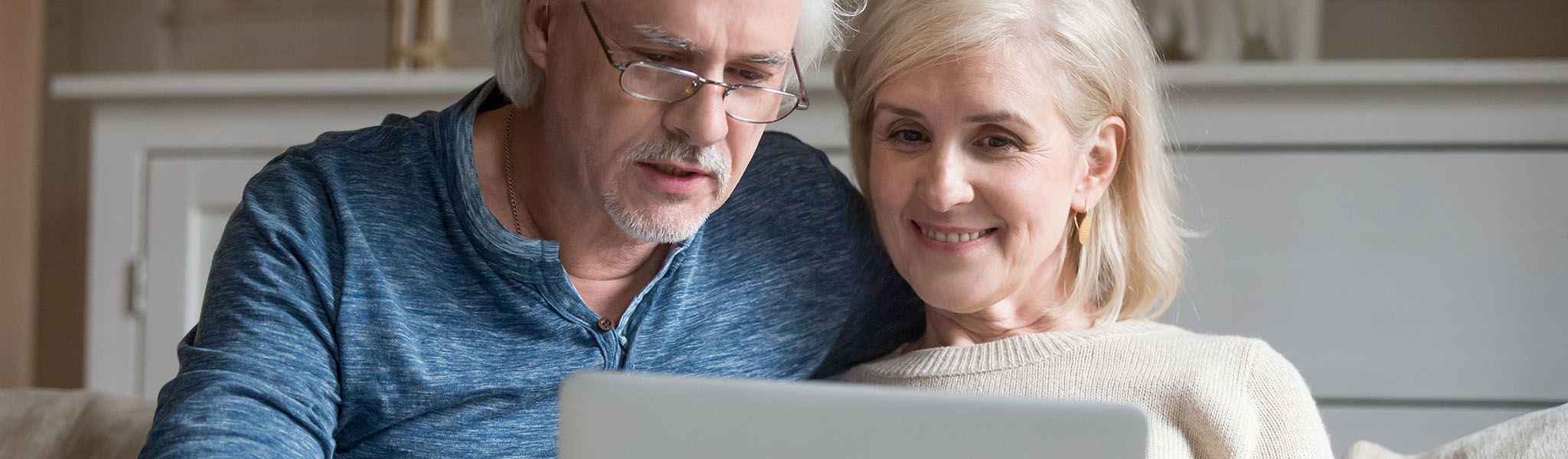 Mature couple looking at computer on couch