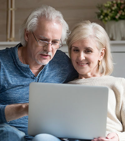 Mature couple looking at computer on couch