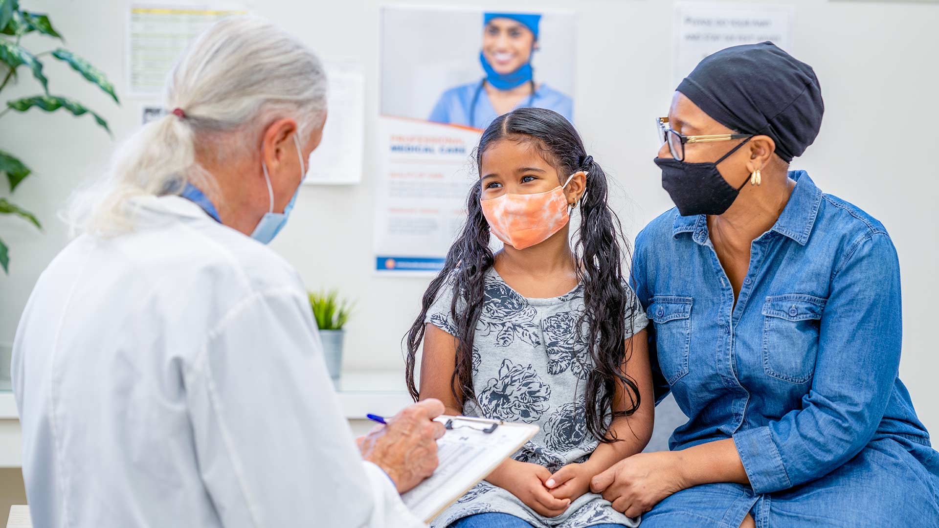 African American mother and daughter sitting at a doctors office meeting