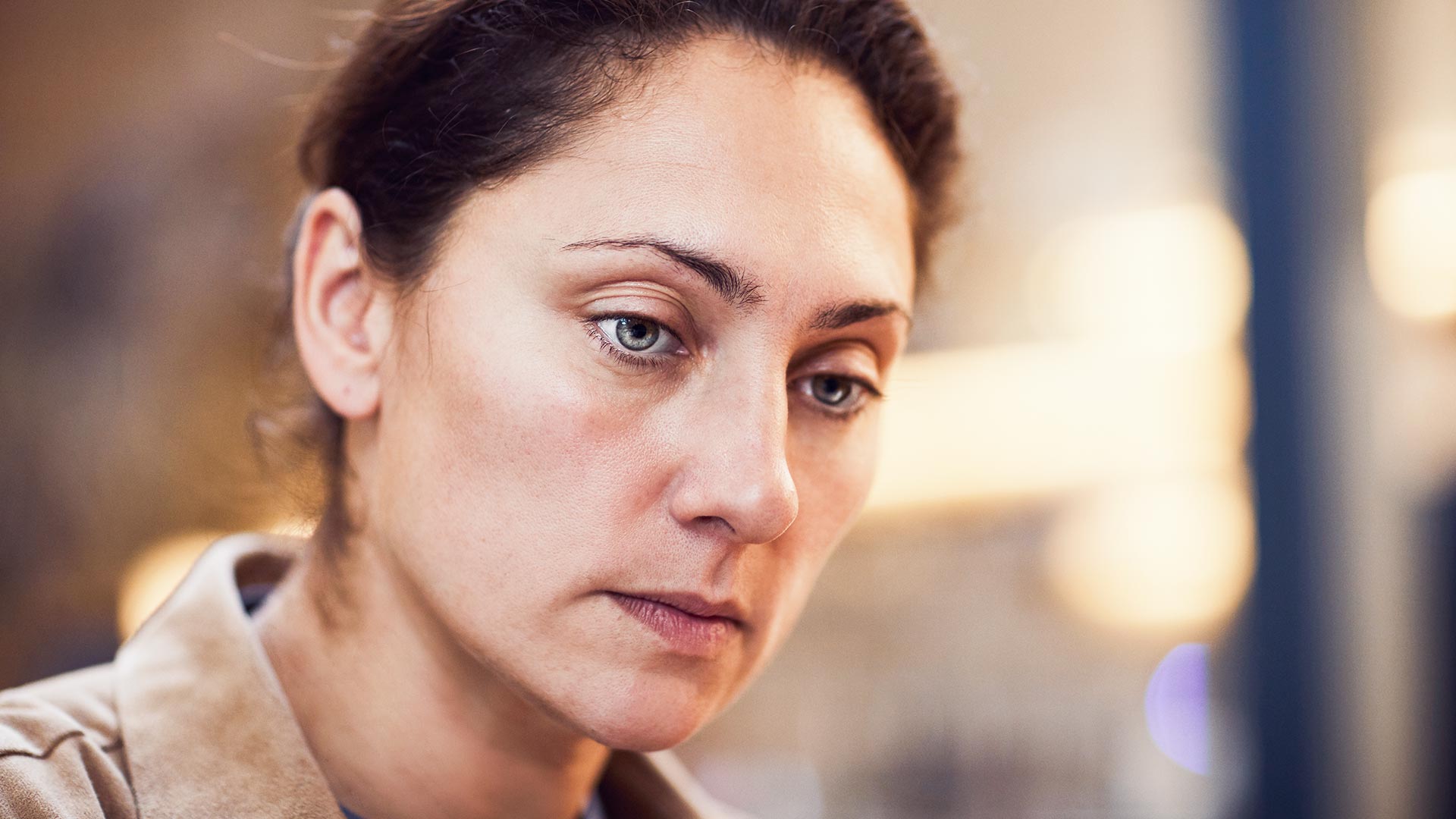 Close-up of mature depressed woman with brown hair and green eyes