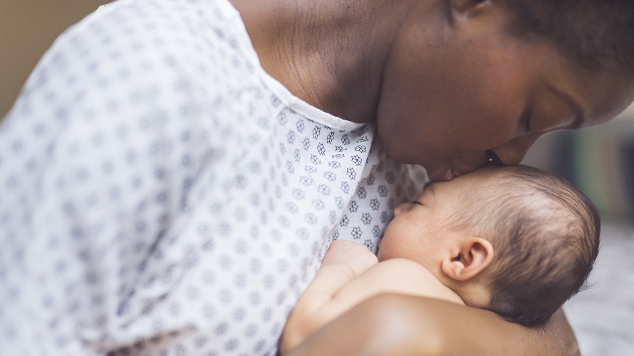 Mother kisses newborn