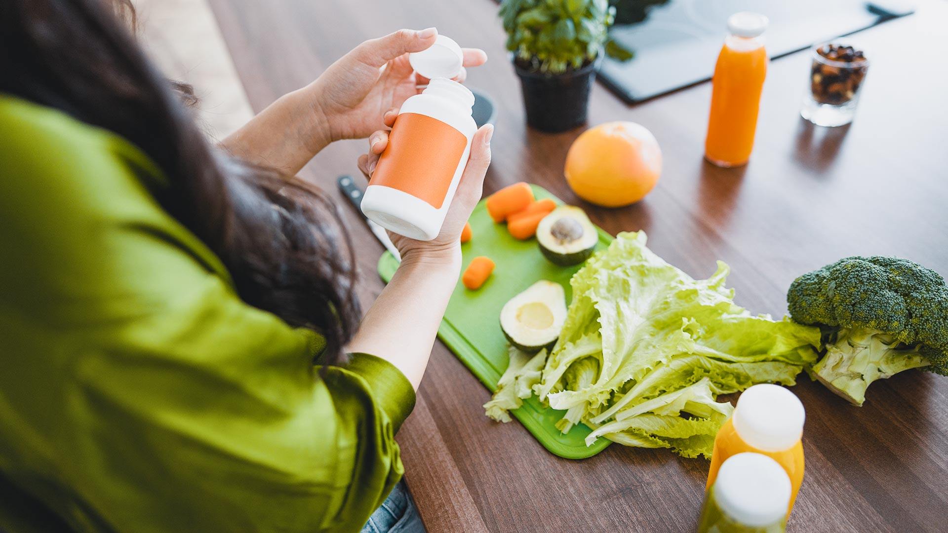 Young lady housewife holding a vitamin supplement