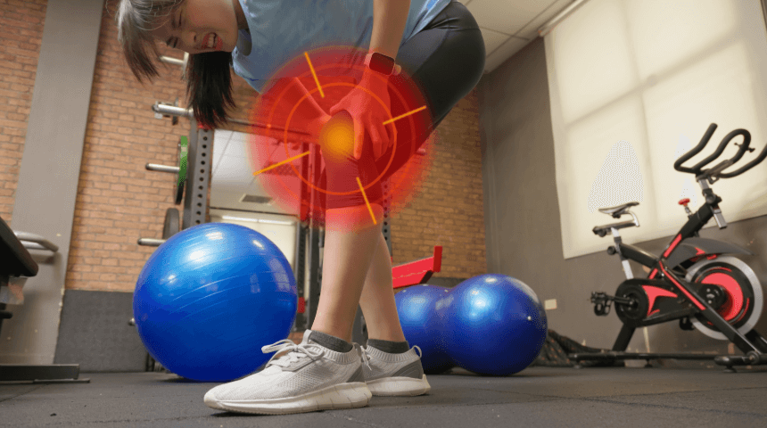 Girl in gym grabbing her knee in pain