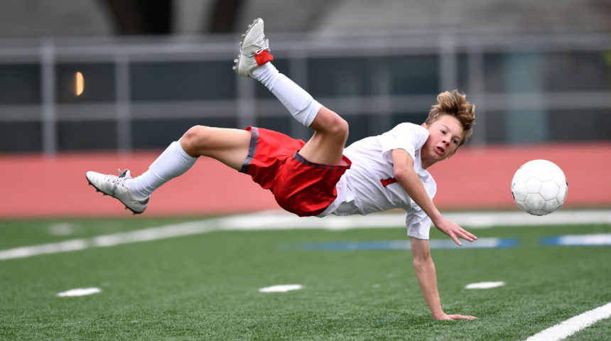 Soccer playing kicking a ball sideways