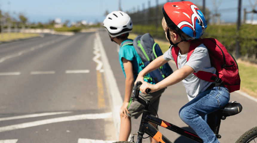 2 boys on bikes looking both ways on the road