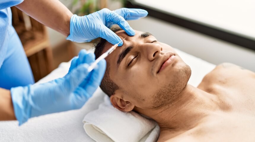 Man getting plastic surgery with needle on forehead